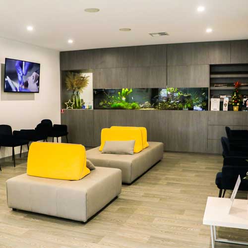 Dental waiting area with modern lounge seating and bright yellow cushions