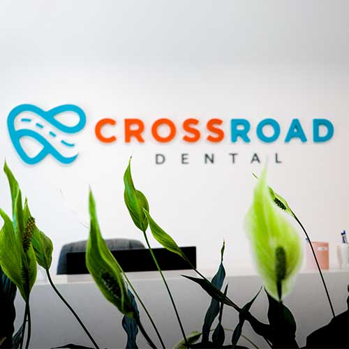 Cross Road Dental logo displayed at the reception desk